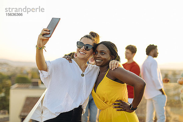 Junge Frauen  die abends auf einer Party ein Selfie machen