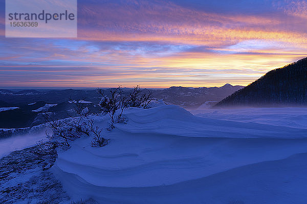 Szenische Ansicht schneebedeckter Berge vor bewölktem Himmel bei Sonnenaufgang  Umbrien  Italien