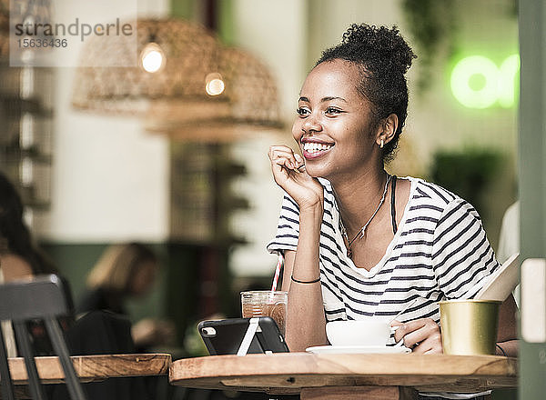 Porträt einer glücklichen jungen Frau in einem Cafe