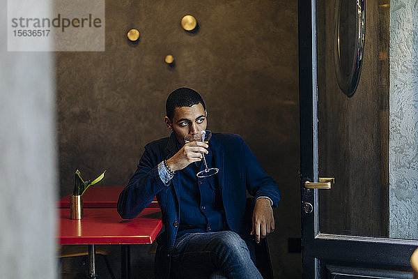 Junger Mann entspannt sich bei einem After-Work-Cocktail