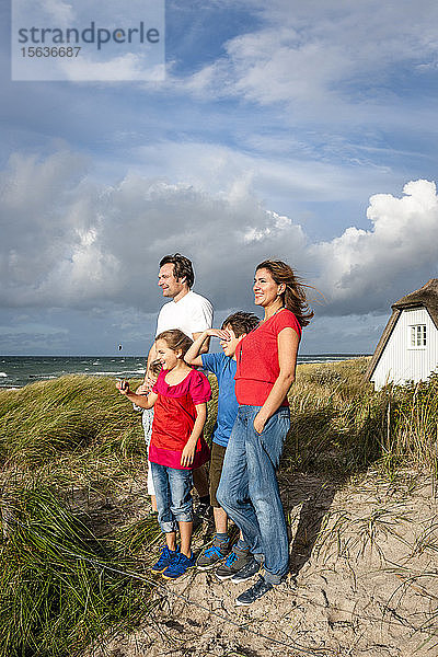 Glückliche Familie steht in einer Stranddüne und schaut auf Aussicht  Darss  Mecklenburg-Vorpommern  Deutschland