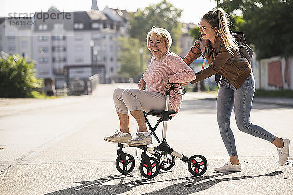 Enkelin und ihre Großmutter amüsieren sich mit Rollator