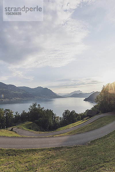 Schweiz  Gersau  Schwyz  kurvenreiche Straße bei Sonnenuntergang mit dem Vierwaldstättersee im Hintergrund