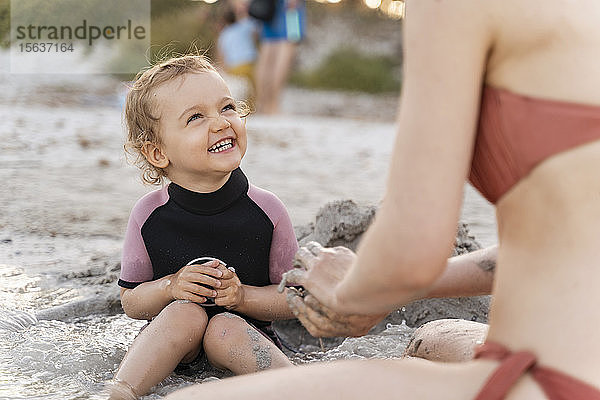 Glückliches Mädchen mit seiner Mutter am Strand