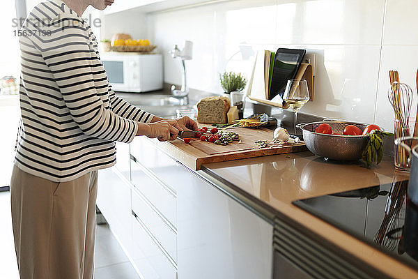 Nahaufnahme einer Frau  die zu Hause in der Küche kocht und Gemüse schneidet