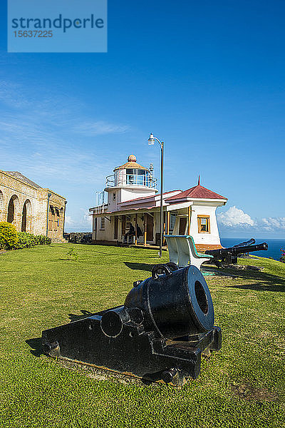 Blick auf die Kanone an Land mit Fort King George im Hintergrund vor blauem Himmel  in Scarborough  Trinidad und Tobago  Karibik