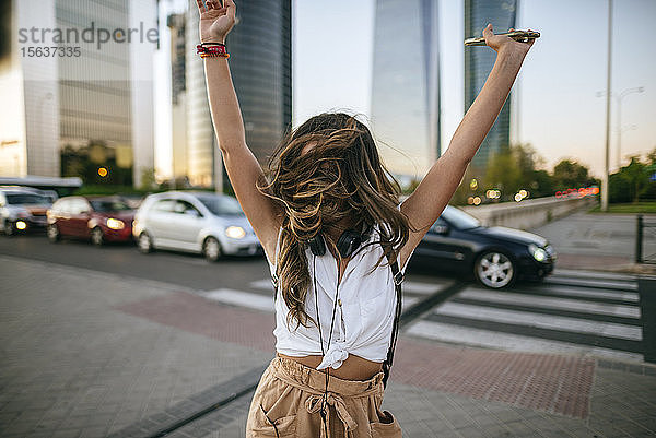 Junge Frau tanzt  Wolkenkratzer im Hintergrund