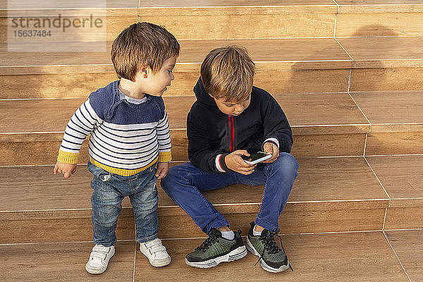 Zwei kleine Jungen schauen aufs Handy
