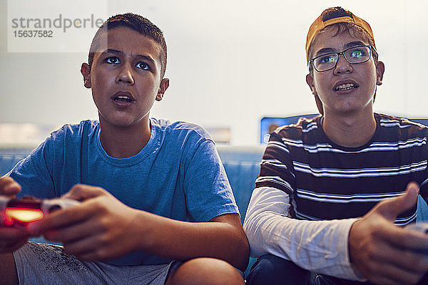 Porträt von jugendlichen Freunden  die in einer Spielhalle Videospiele spielen