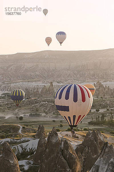 Bunte Heißluftballons überfliegen bei Sonnenuntergang den Goreme-Nationalpark  Kappadokien  Türkei