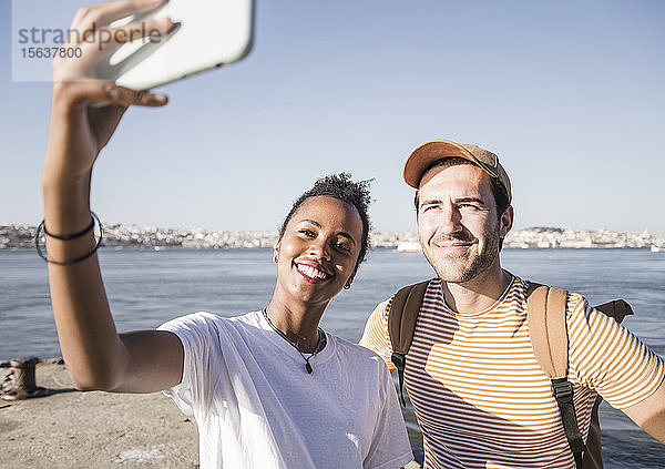 Glückliches junges Paar beim Selfie am Pier am Wasser  Lissabon  Portugal