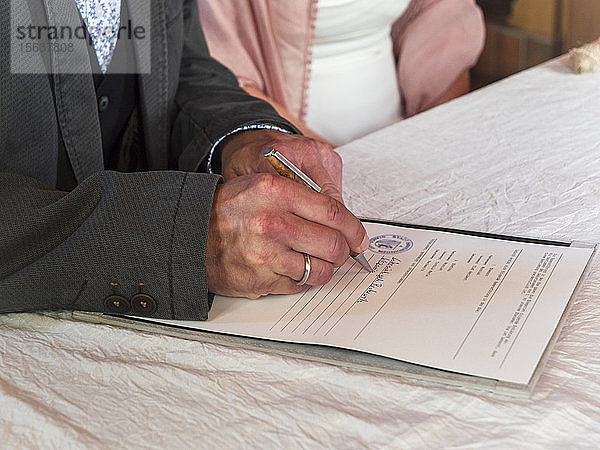 Älteres Ehepaar heiratet  Bräutigam unterzeichnet Dokument im Standesamt