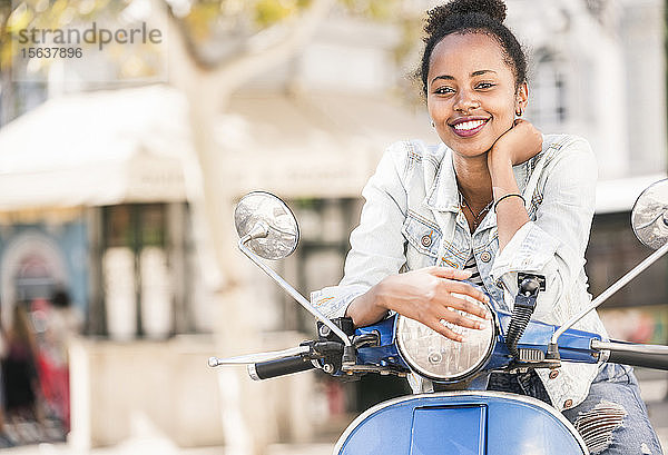 Porträt einer glücklichen jungen Frau mit Motorroller in der Stadt  Lissabon  Portugal