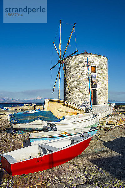 Boote liegen an einer traditionellen Windmühle vor blauem Himmel in Korfu-Stadt  Ionische Inseln  Griechenland