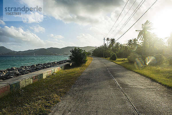 Abnehmende Perspektive einer leeren Straße entlang des Strandes in Carriacou  Grenada  Karibik