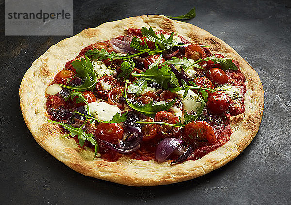 Nahaufnahme einer Pizza mit Tomaten  Zwiebeln  Mozzarella und Basilikum