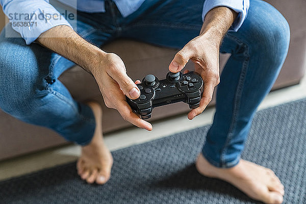Hände eines barfüssigen Mannes beim Computerspiel zu Hause  Nahaufnahme