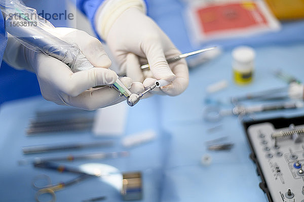 Zahnarzt Chirurg zeigt ein Implantat