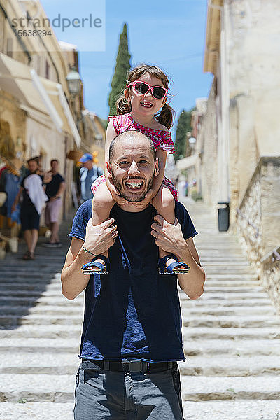 Porträt eines glücklichen Vaters mit einer kleinen Tochter auf den Schultern  Pollenca  Mallorca  Spanien