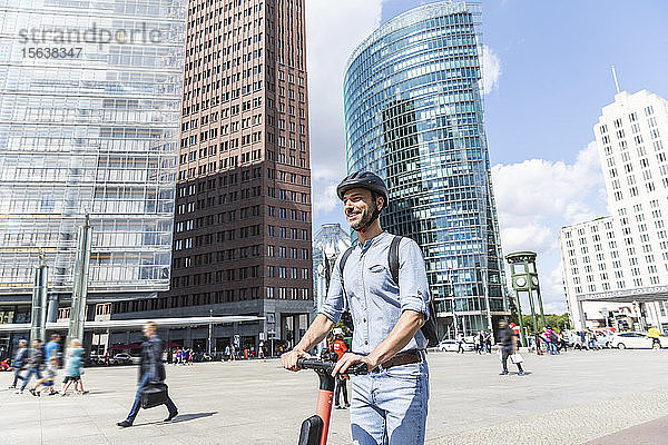 Geschäftsmann mit E-Scooter auf dem Stadtplatz  Berlin  Deutschland