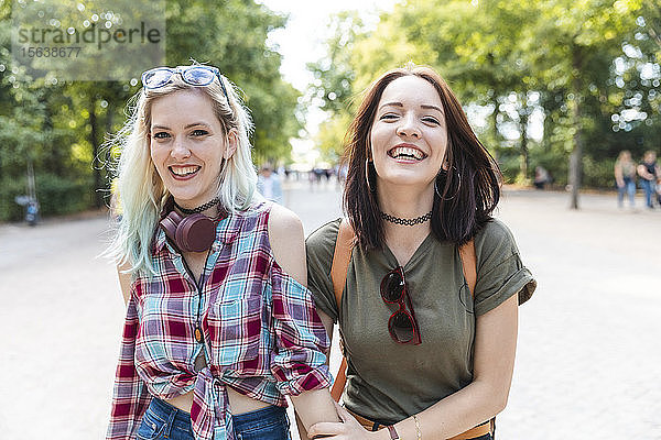 Porträt von zwei glücklichen Freunden zusammen in einem Park