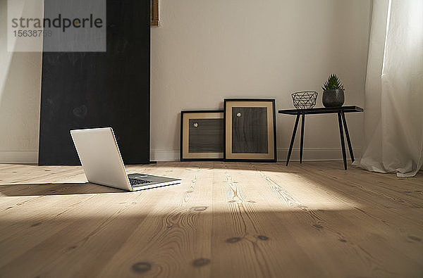 Laptop auf Holzboden in einem modernen Raum