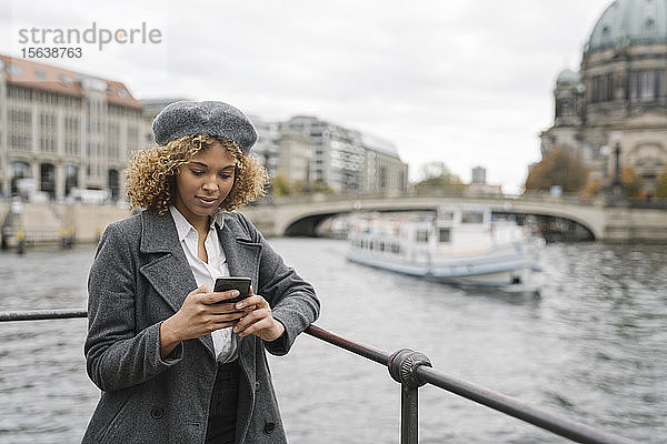 Touristin mit Smartphone in der Stadt mit dem Berliner Dom im Hintergrund  Berlin  Deutschland