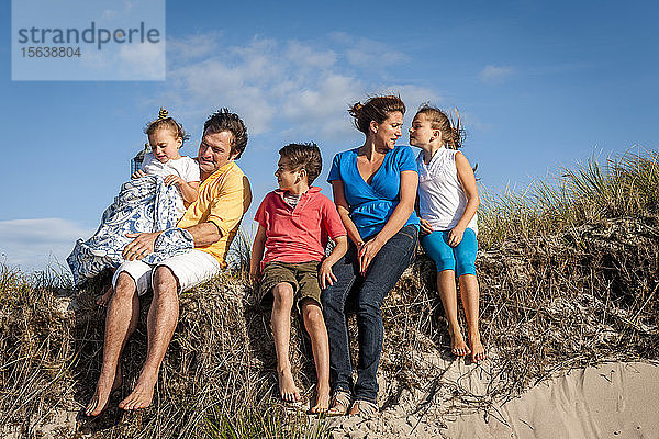 Familie sitzt in einer Stranddüne  Darß  Mecklenburg-Vorpommern  Deutschland