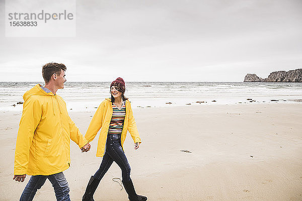 Junge Frau in gelben Regenjacken und Strandspaziergang  Bretagne  Frankreich