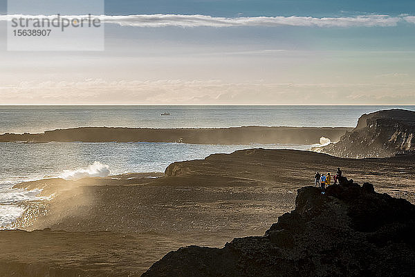 Freunde genießen die Aussicht in der Nähe des Reykjanes-Leuchtturms bei Sonnenuntergang  Halbinsel Reykjanes; Island