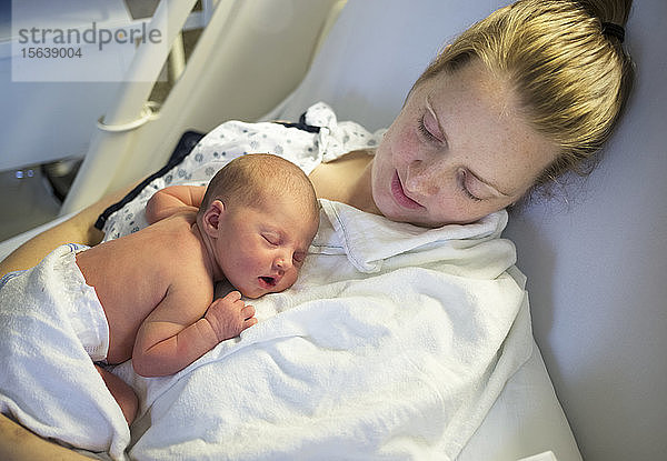 Neugeborenes Baby schläft an der Brust der Mutter in einem Krankenhausbett; Vancouver  British Columbia  Kanada