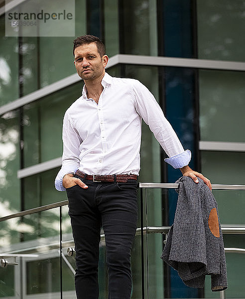 Geschäftsmann vor einem Gebäude in lässiger Pose; Vancouver  British Columbia  Kanada