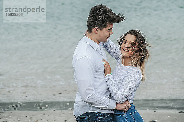 Porträt eines jungen Paares  das sich am Strand zärtlich umarmt; Wellington  Nordinsel  Neuseeland