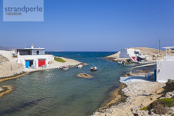 Weiße Häuser mit bunten Akzenten entlang der Küste mit Blick auf das Ägäische Meer und den Horizont mit blauem Himmel; Konstantinos  Insel Milos  Kykladen  Griechenland