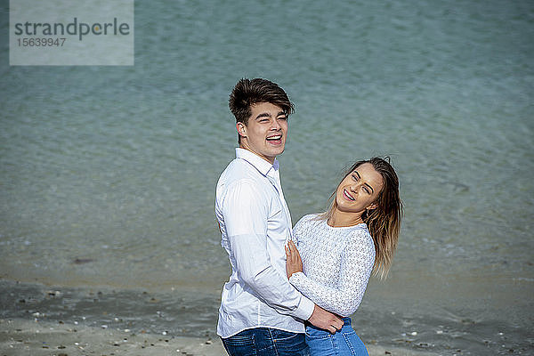 Porträt eines jungen Paares  das sich am Strand zärtlich umarmt; Wellington  Nordinsel  Neuseeland