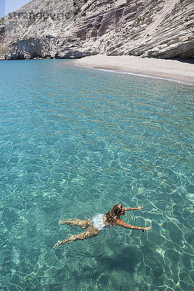 Touristin beim Schwimmen im klaren  türkisfarbenen Wasser der Bucht von Galazia Nera; Insel Polyaigos  Kykladen  Griechenland