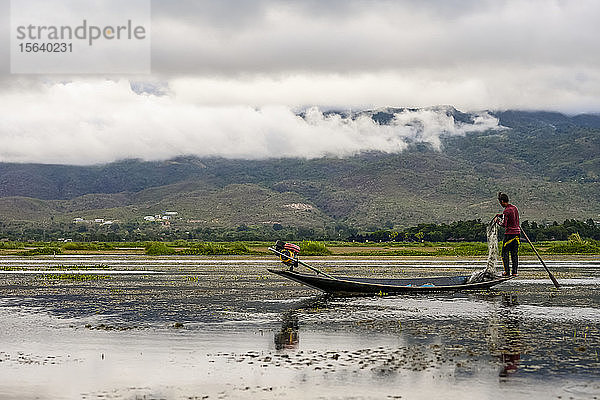 Fischer am Rande des Bootes mit Netz und Paddel im Inle-See; Yawngshwe  Shan-Staat  Myanmar