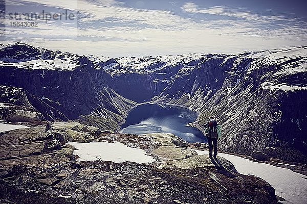 Junge Frau beim Aufstieg zur Trolltunga  Blick in den Fjord  Sørfjord  bei Odda  Norwegen  Europa