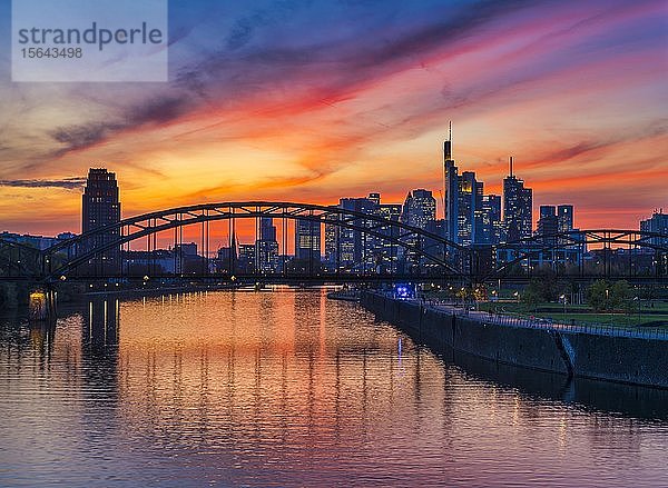 Skyline von Frankfurt vor Sonnenuntergang mit beleuchteten Wolkenkratzern und Spiegelungen im Main  Frankfurt am Main  Hessen  Deutschland  Europa