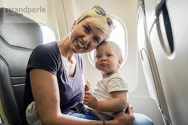 Mutter mit spielendem Baby in einem Passagierflugzeug  Polen  Europa