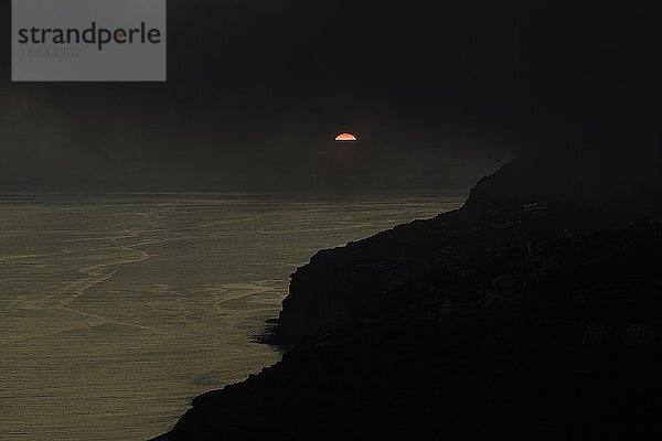 Dramatischer bewölkter Himmel bei Sonnenuntergang  Steilküste bei Arco da Calheta  Insel Madeira  Portugal  Europa