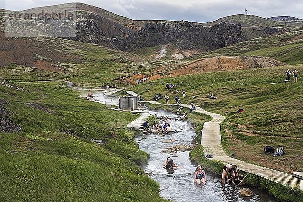 Menschen beim Baden in den heißen Thermalquellen von Reykjadalur  Geothermalgebiet  bei Hveragerdi  Südisland  Island  Europa