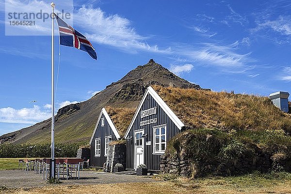 Holzhäuser  Restaurant Arnarbaer  isländische Flagge  hinter dem Berg Stapafell  Arnarstapi  Halbinsel Snæfellsness  Island  Europa
