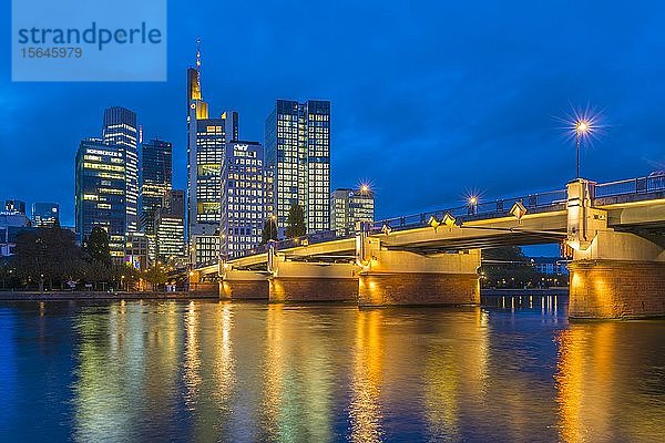 Skyline von Frankfurt mit beleuchteten Wolkenkratzern und Untermainbrücke mit Wasserspiegelungen im Main  Schaumainkai  Frankfurt am Main  Hessen  Deutschland  Europa