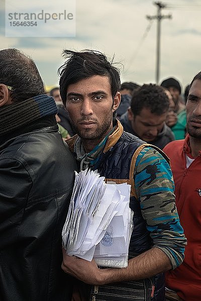 Flüchtling mit einem Stapel Papiere in der Schlange für ein Visum  Flüchtlingslager Idomeni an der griechisch-mazedonischen Grenze  Idomeni  Griechenland  Europa