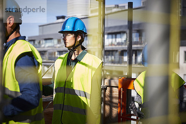 Männliche und weibliche Architekten in Arbeitsschutzkleidung auf der Baustelle