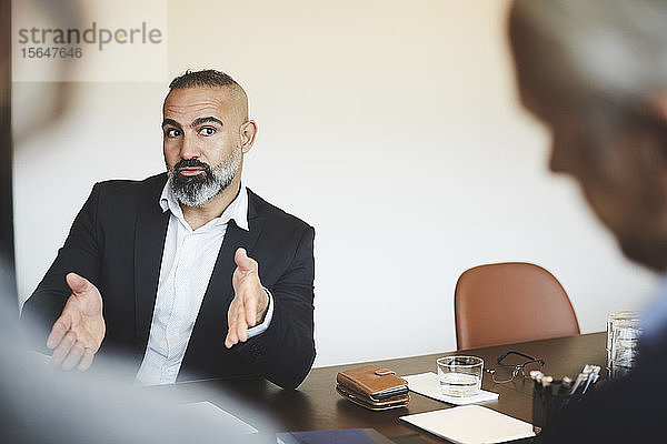 Älterer Finanzberater diskutiert am Konferenztisch