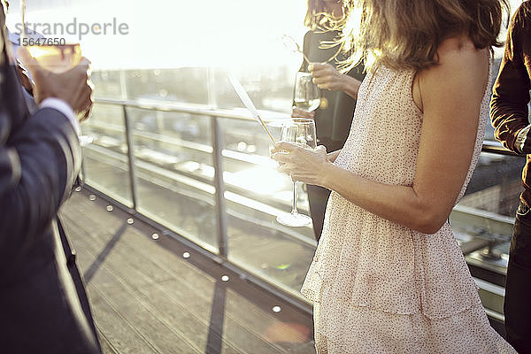 Ein Teil der Geschäftsleute genießt Getränke nach der Arbeit auf der Büroterrasse