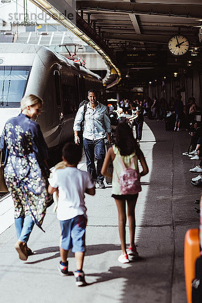 Familie zu Fuss mit dem Zug auf dem Bahnsteig des Bahnhofs