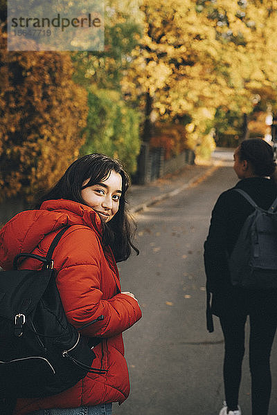 Porträt eines Teenagers  der im Herbst auf der Straße geht